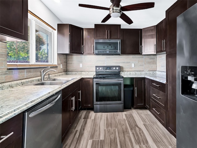 kitchen with light hardwood / wood-style floors, sink, dark brown cabinetry, and appliances with stainless steel finishes