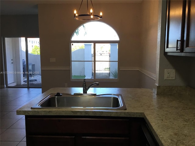 kitchen featuring a wealth of natural light, dark brown cabinets, and sink