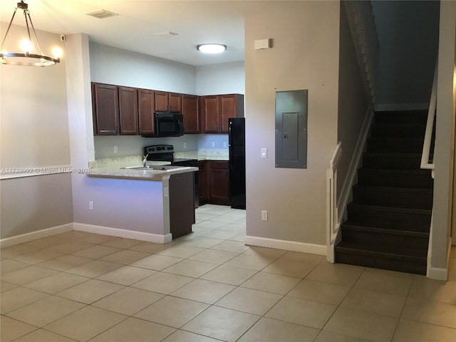 kitchen featuring pendant lighting, black appliances, kitchen peninsula, light tile patterned flooring, and electric panel