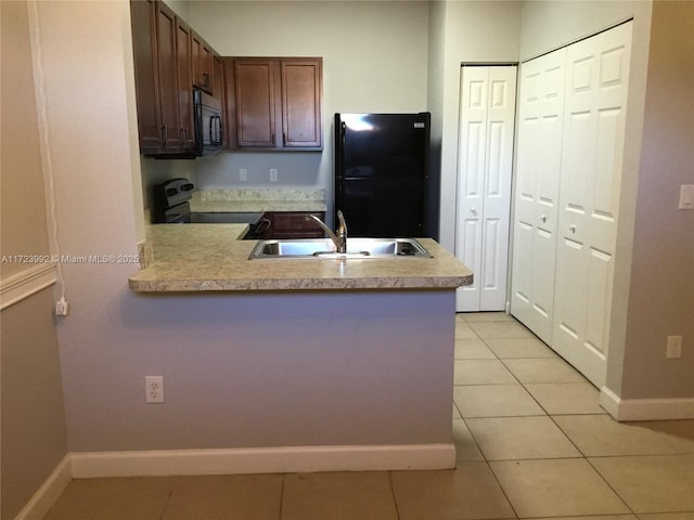 kitchen featuring sink, light tile patterned floors, black appliances, and kitchen peninsula