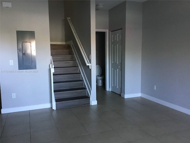 stairs with tile patterned floors and electric panel