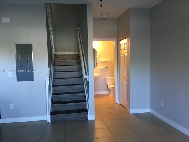 stairway with electric panel and tile patterned flooring