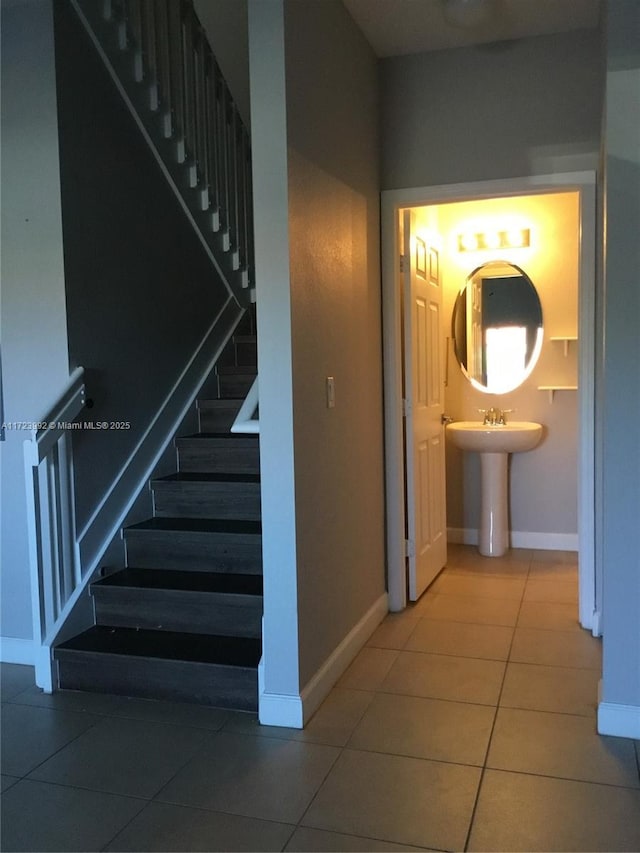 stairs featuring tile patterned floors and sink