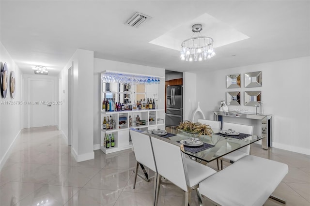 dining room featuring visible vents, a notable chandelier, and baseboards