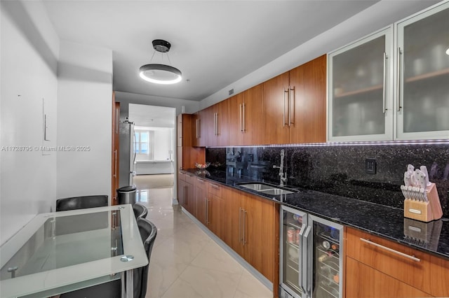 kitchen with beverage cooler, decorative light fixtures, dark stone counters, tasteful backsplash, and sink