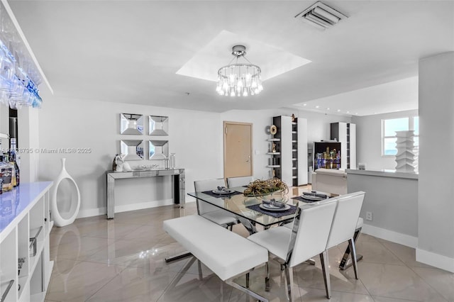 tiled dining room featuring a chandelier