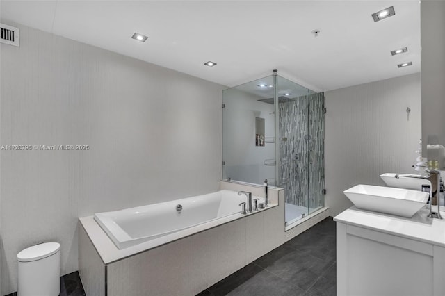 full bathroom featuring a stall shower, a garden tub, vanity, and tile patterned floors