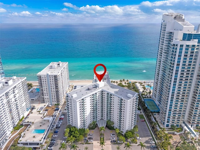 birds eye view of property featuring a water view and a beach view