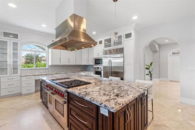 kitchen featuring a kitchen island, built in appliances, white cabinetry, dark brown cabinets, and island range hood