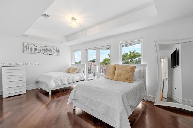 bedroom featuring a tray ceiling and dark hardwood / wood-style floors