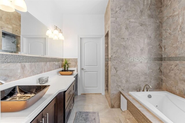 bathroom featuring vanity, tile walls, tile patterned floors, and independent shower and bath