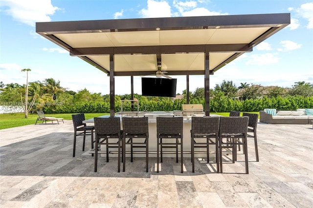 view of patio / terrace with ceiling fan, a gazebo, exterior kitchen, and an outdoor bar