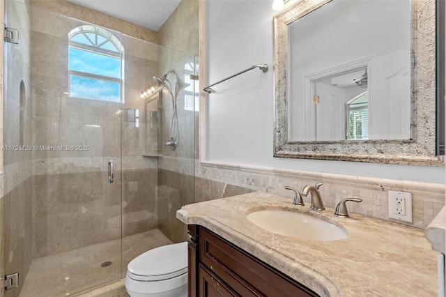 bathroom featuring walk in shower, vanity, tile walls, and toilet