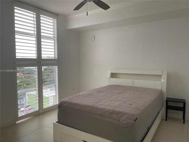 bedroom featuring ceiling fan, multiple windows, light tile patterned floors, and ornamental molding