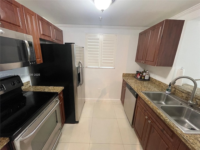 kitchen with appliances with stainless steel finishes, dark stone countertops, sink, light tile patterned floors, and crown molding