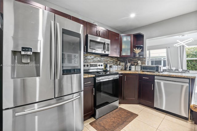 kitchen with decorative backsplash, light stone countertops, appliances with stainless steel finishes, and light tile patterned flooring