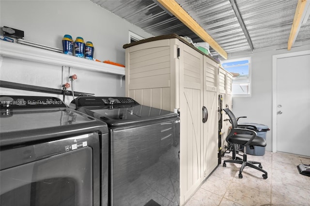 clothes washing area featuring light tile patterned floors and washing machine and dryer