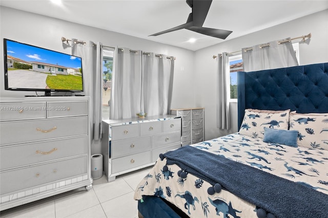 bedroom featuring ceiling fan, light tile patterned floors, and multiple windows