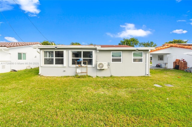 rear view of property featuring a lawn and ac unit