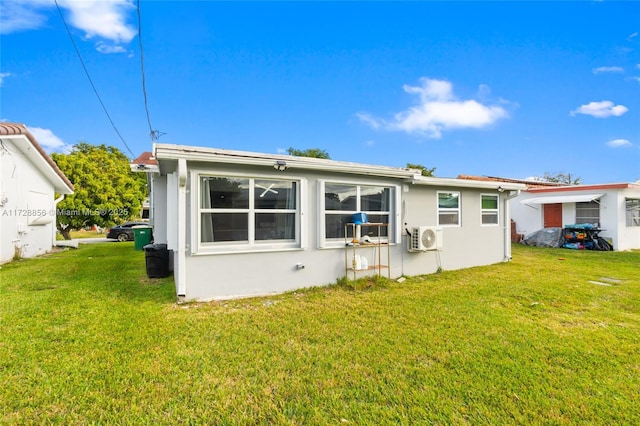 back of house with ac unit and a yard