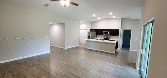 kitchen with stainless steel appliances, ceiling fan, lofted ceiling, light countertops, and wood finished floors