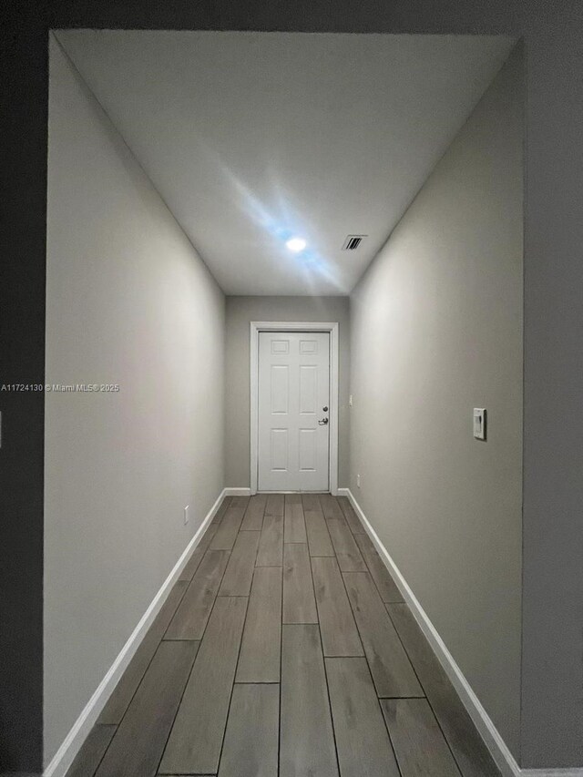 hall featuring wood finished floors and baseboards