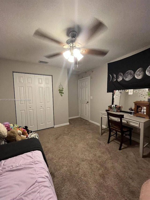 carpeted bedroom featuring ceiling fan, a closet, and a textured ceiling