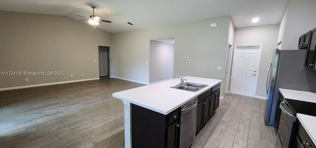 kitchen with a sink, stainless steel dishwasher, a ceiling fan, electric range oven, and light wood finished floors