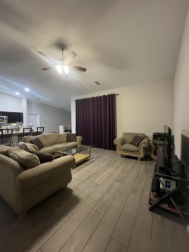 living room featuring ceiling fan and lofted ceiling