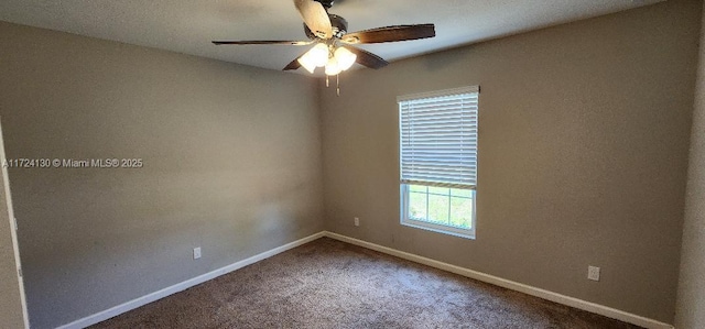 carpeted spare room with a ceiling fan and baseboards