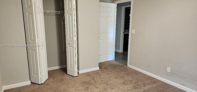 unfurnished bedroom featuring carpet, baseboards, and a closet