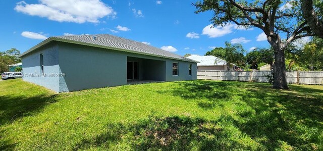 rear view of property featuring stucco siding