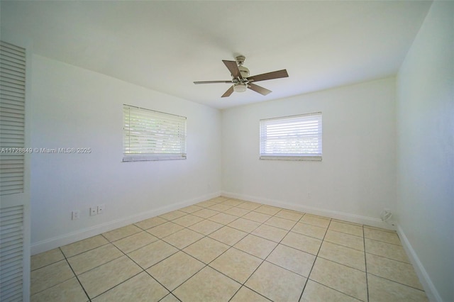 empty room with ceiling fan and light tile patterned floors