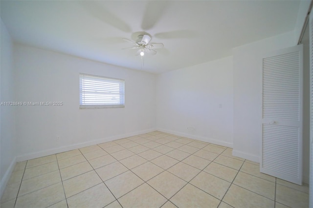 tiled spare room featuring ceiling fan