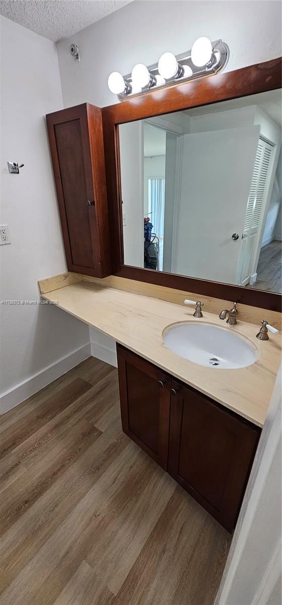 bathroom featuring vanity, hardwood / wood-style floors, and a textured ceiling