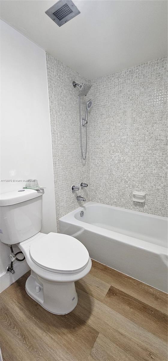 bathroom with tiled shower / bath and toilet