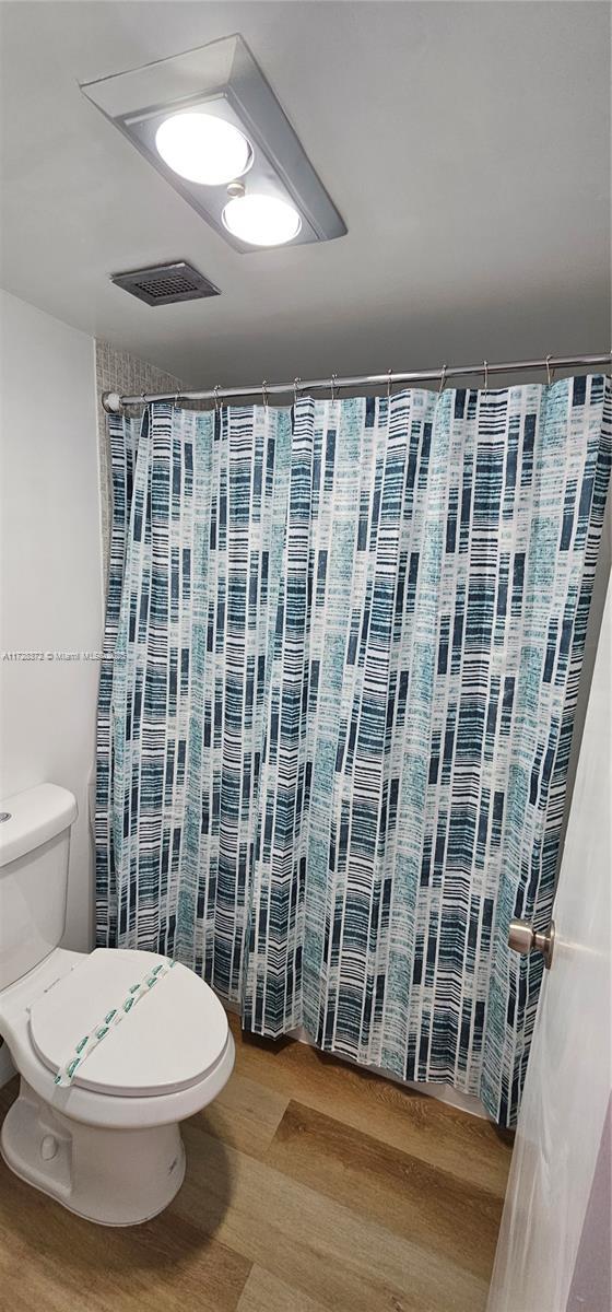 bathroom featuring hardwood / wood-style flooring and toilet