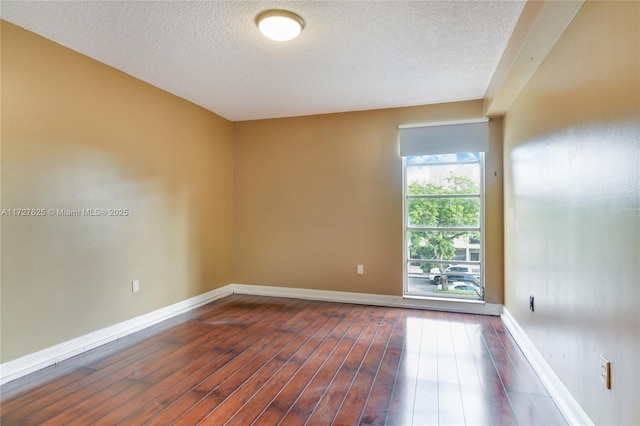 unfurnished room with a textured ceiling and hardwood / wood-style flooring