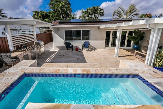 view of pool featuring an outdoor kitchen, a grill, and a patio area