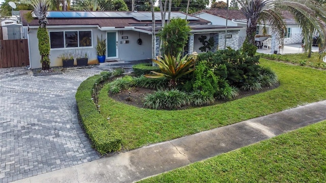 view of front of home featuring a front yard and solar panels