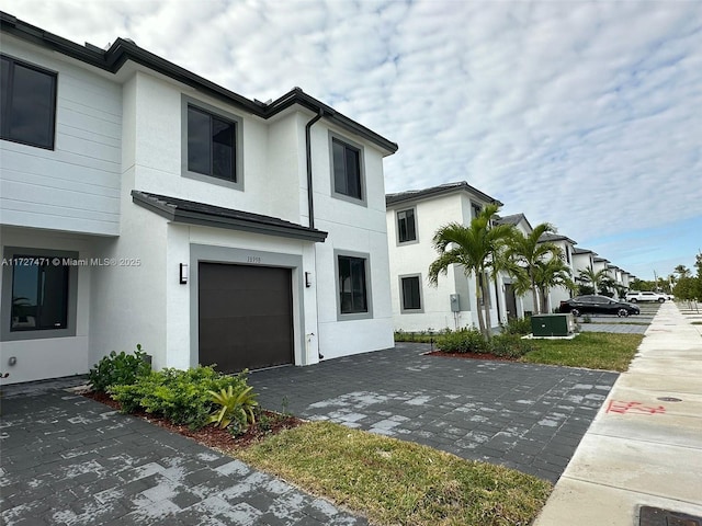 view of front facade featuring a garage and central AC