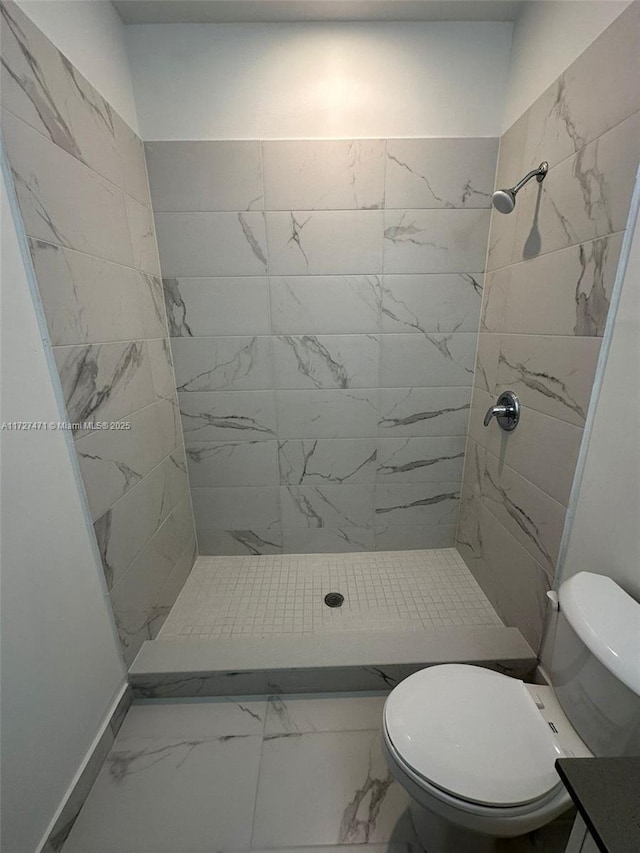 bathroom with tiled shower and toilet