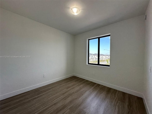 empty room with dark hardwood / wood-style flooring