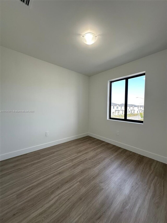 spare room with dark hardwood / wood-style floors