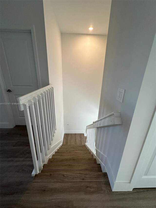 staircase with hardwood / wood-style flooring