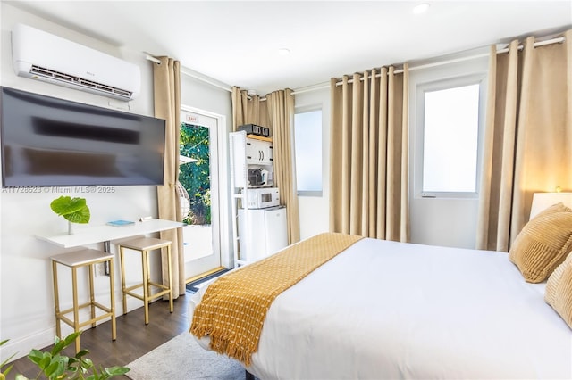 bedroom with a wall unit AC and dark hardwood / wood-style flooring