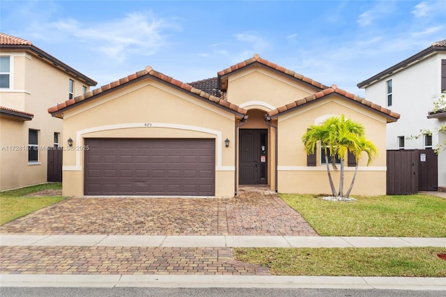 mediterranean / spanish-style home featuring a front lawn and a garage