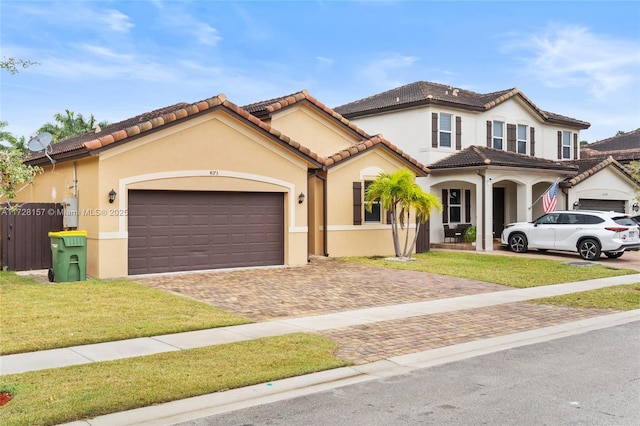 mediterranean / spanish home featuring a front lawn and a garage