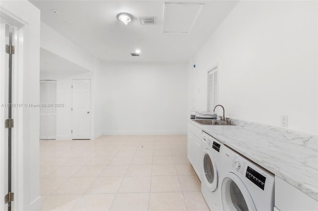 laundry area with light tile patterned floors, independent washer and dryer, and sink