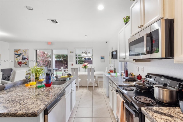 kitchen featuring light tile patterned floors, white cabinets, appliances with stainless steel finishes, and light stone countertops